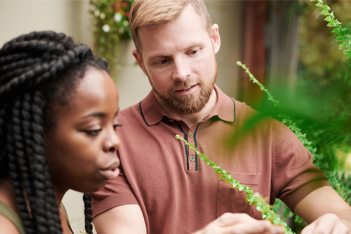 Man and woman looking at plants and discussing them