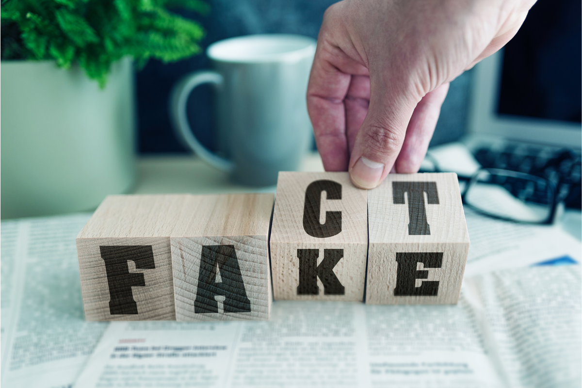 blocks with letters and hand changing them from "fake" to "fact"