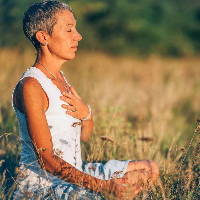 woman in a field meditating
